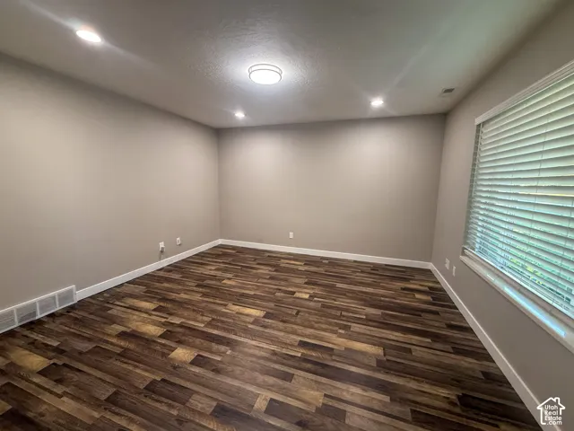 Wood-finish flooring, recessed lighting, ceiling-mounted light fixture, neutral wall color, and window with blinds