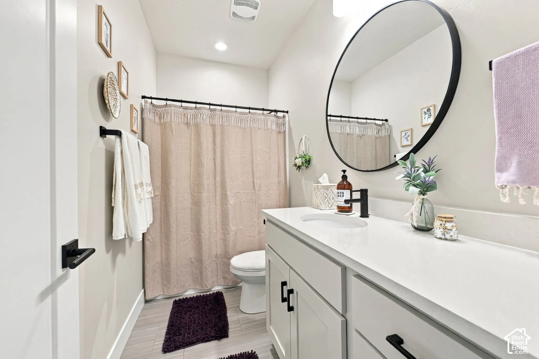White vanity with black hardware, integrated sink, and white countertop