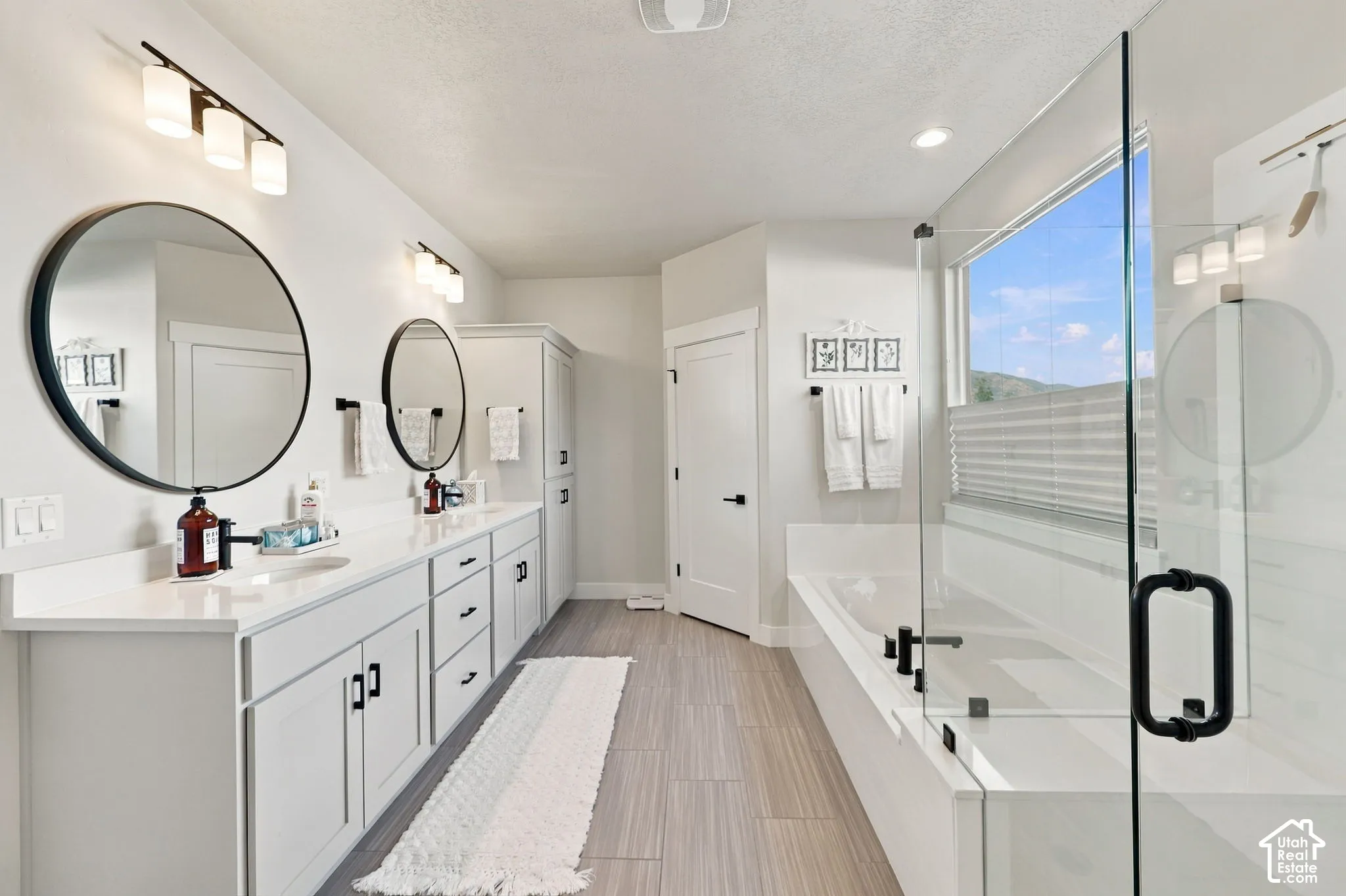 Dual vanities with round mirrors and modern lighting