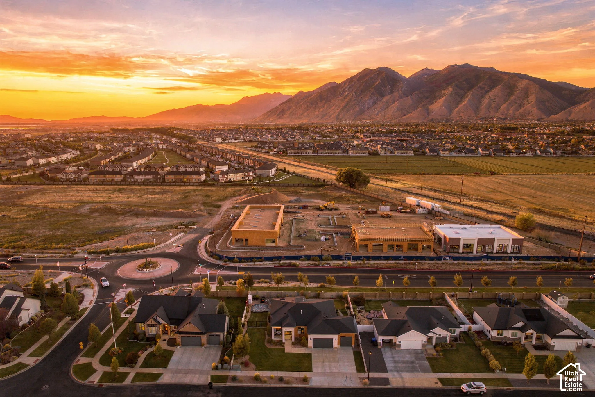 Mountain backdrop, new residential development, established housing, roundabout with landscaping, commercial construction