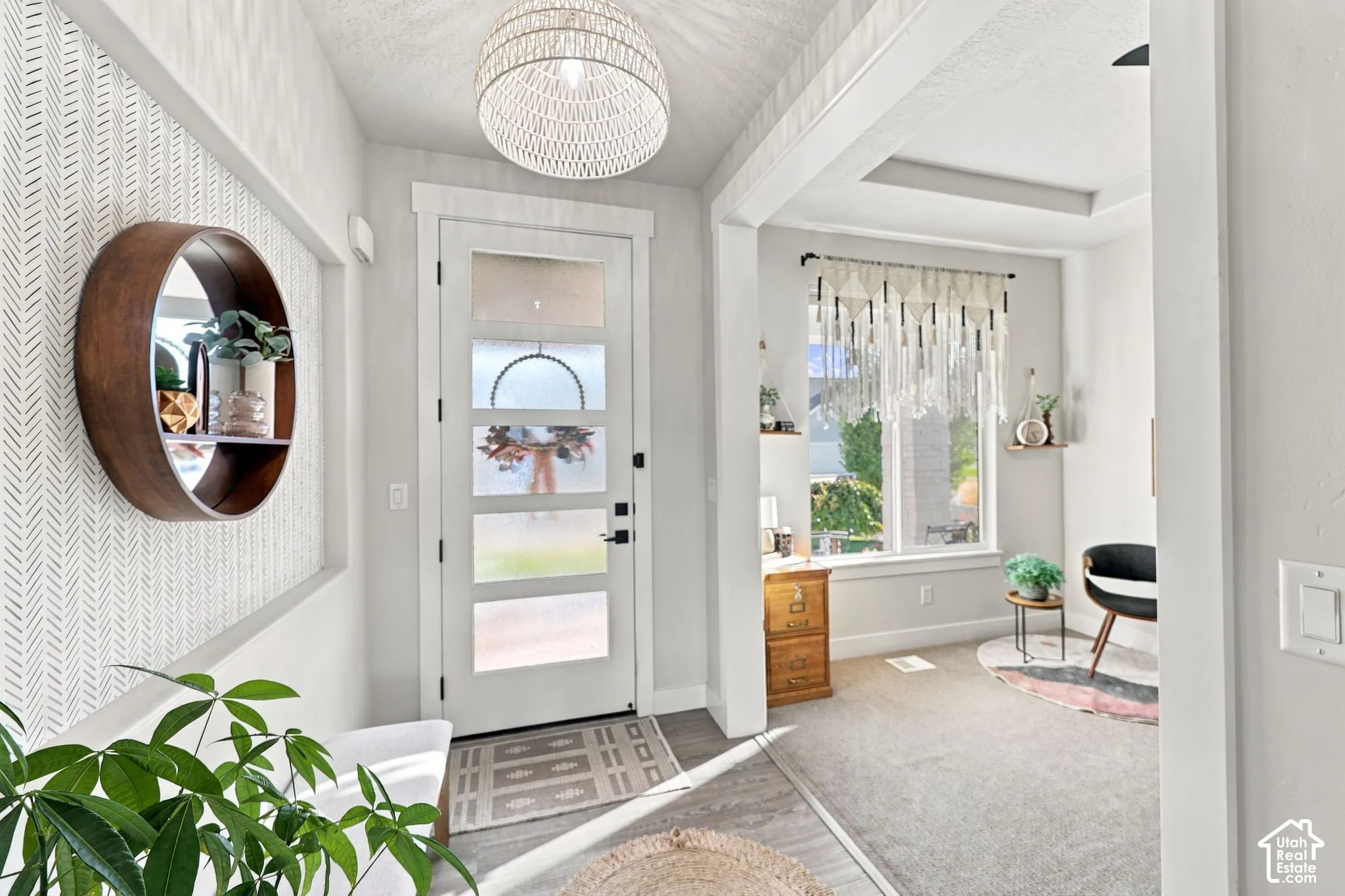 Entryway featuring a decorative pendant light fixture, a paneled door with frosted glass inserts, and a patterned wall accent