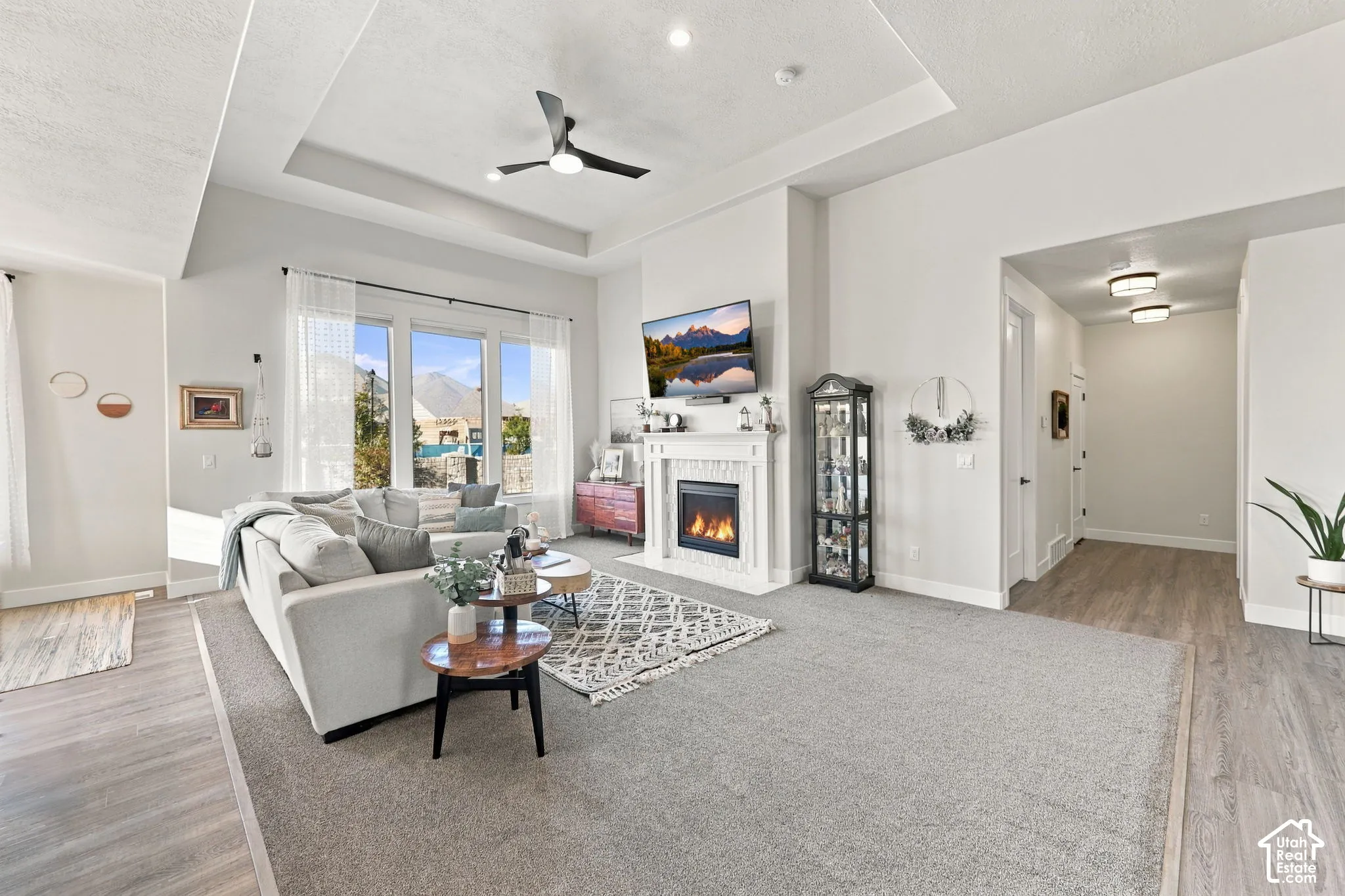Living area featuring a tray ceiling, recessed lighting, and a ceiling fan