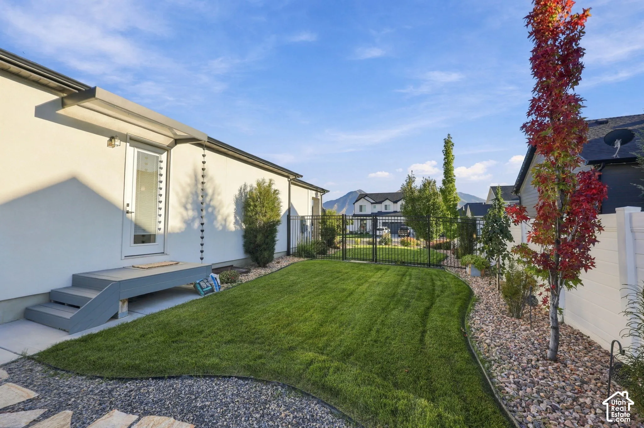 Expansive lawn with a decorative rock border and mature trees