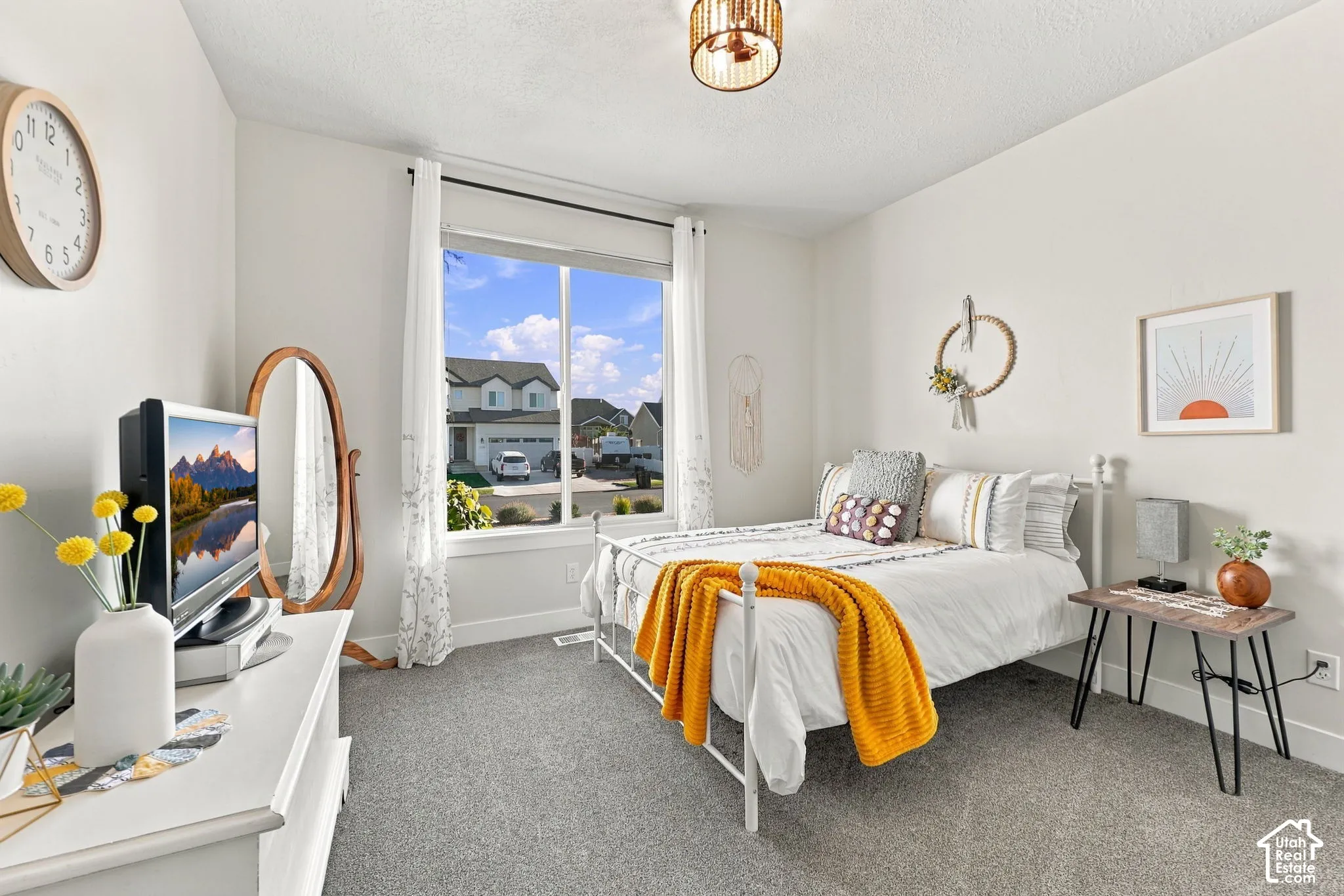 Carpeted room with a large window, a metal bed frame, a built-in light fixture, and white wall finishes