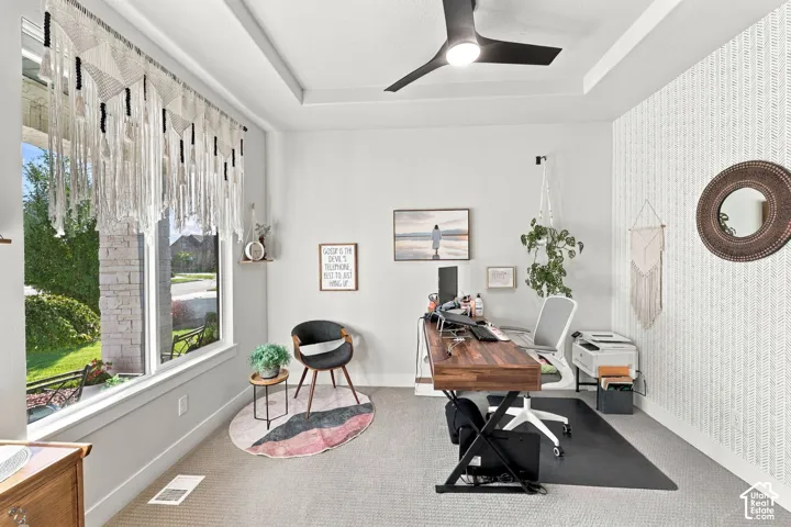 Large picture window, tray ceiling, recessed lighting, wood-finish desk, patterned accent wall
