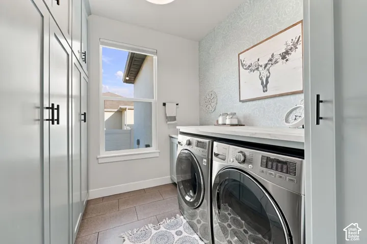 Laundry space featuring built-in cabinetry with matte black hardware, a single window, and a light-colored countertop