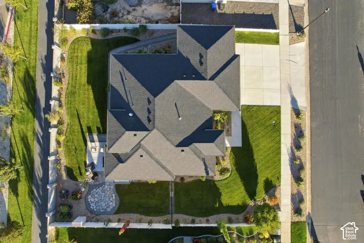 Asphalt shingle roofing, concrete driveway, concrete walkways, manicured lawn, and landscaped perimeter