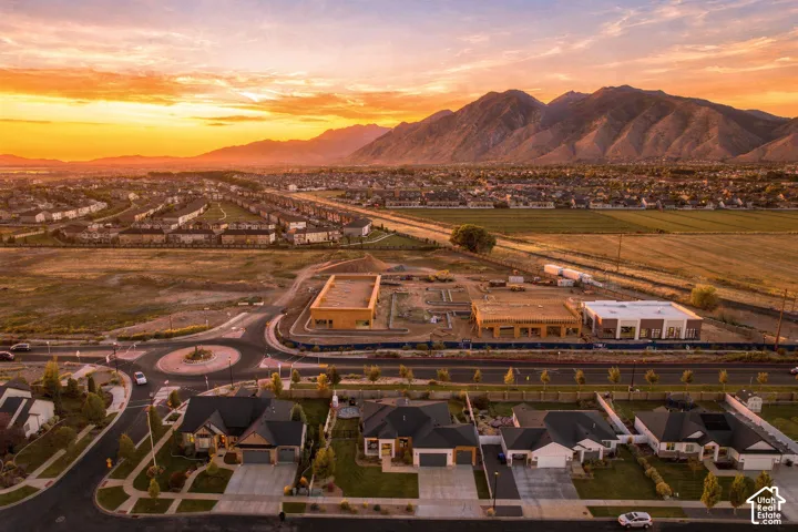 Mountain backdrop, new residential development, established housing, roundabout with landscaping, commercial construction
