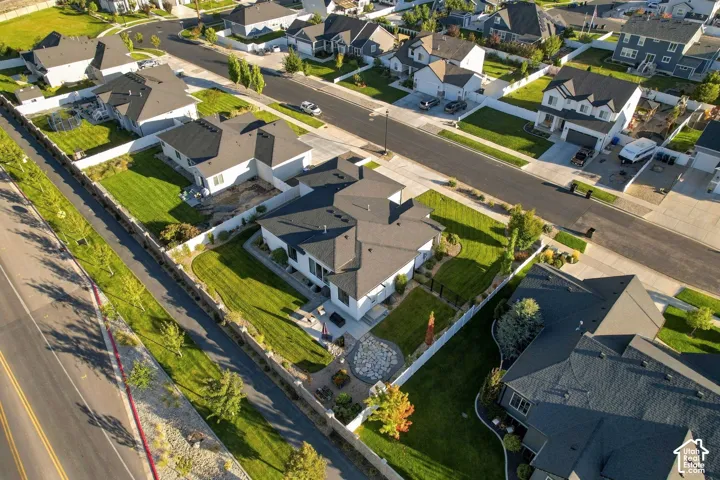 Spacious property with a manicured lawn, paved driveway, and mature landscaping, bordered by a privacy fence