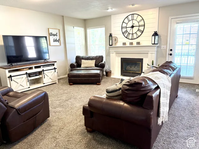 Fireplace with white mantel, shiplap accent wall, and built-in shelving