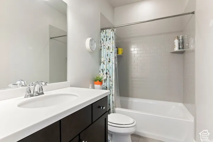 White vanity with an integrated sink and chrome faucet, dark wood-finish cabinetry, and a full-width mirror