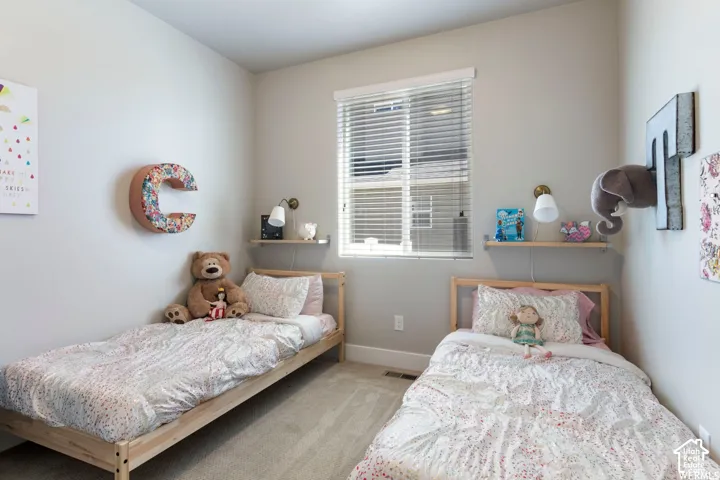 Carpeted room featuring a window with blinds, two wall-mounted shelves, and two wall-mounted sconces