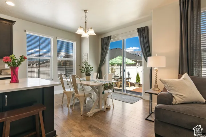 Hardwood-finish flooring, white countertops, dark cabinetry, sliding glass door, and a built-in chandelier