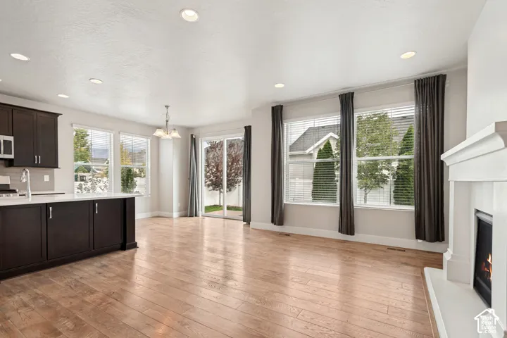 Wood-finish flooring throughout, recessed ceiling lighting, built-in fireplace, and a sliding glass door