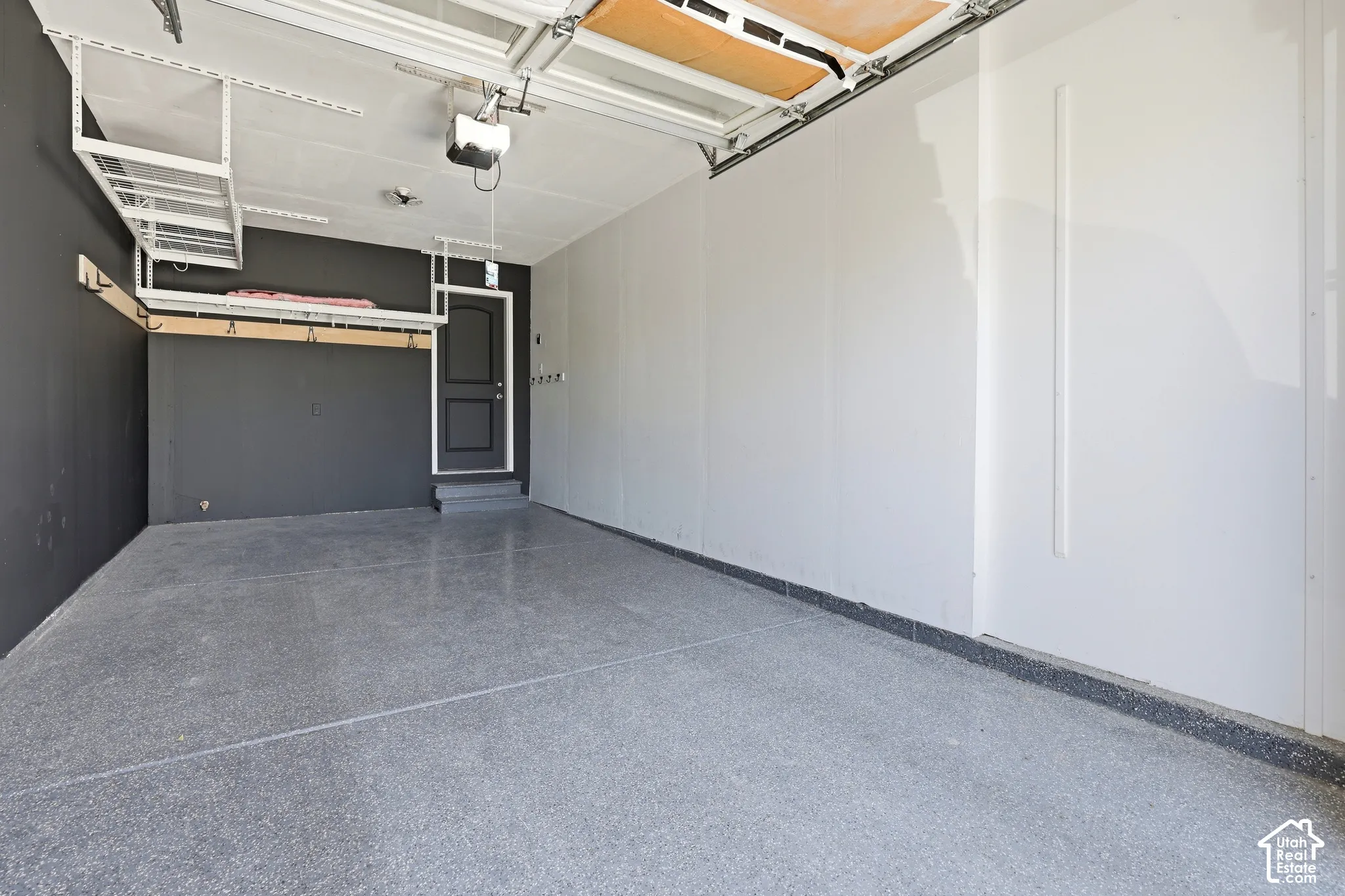 Epoxy-coated flooring, overhead storage racks, garage door opener, and interior access door
