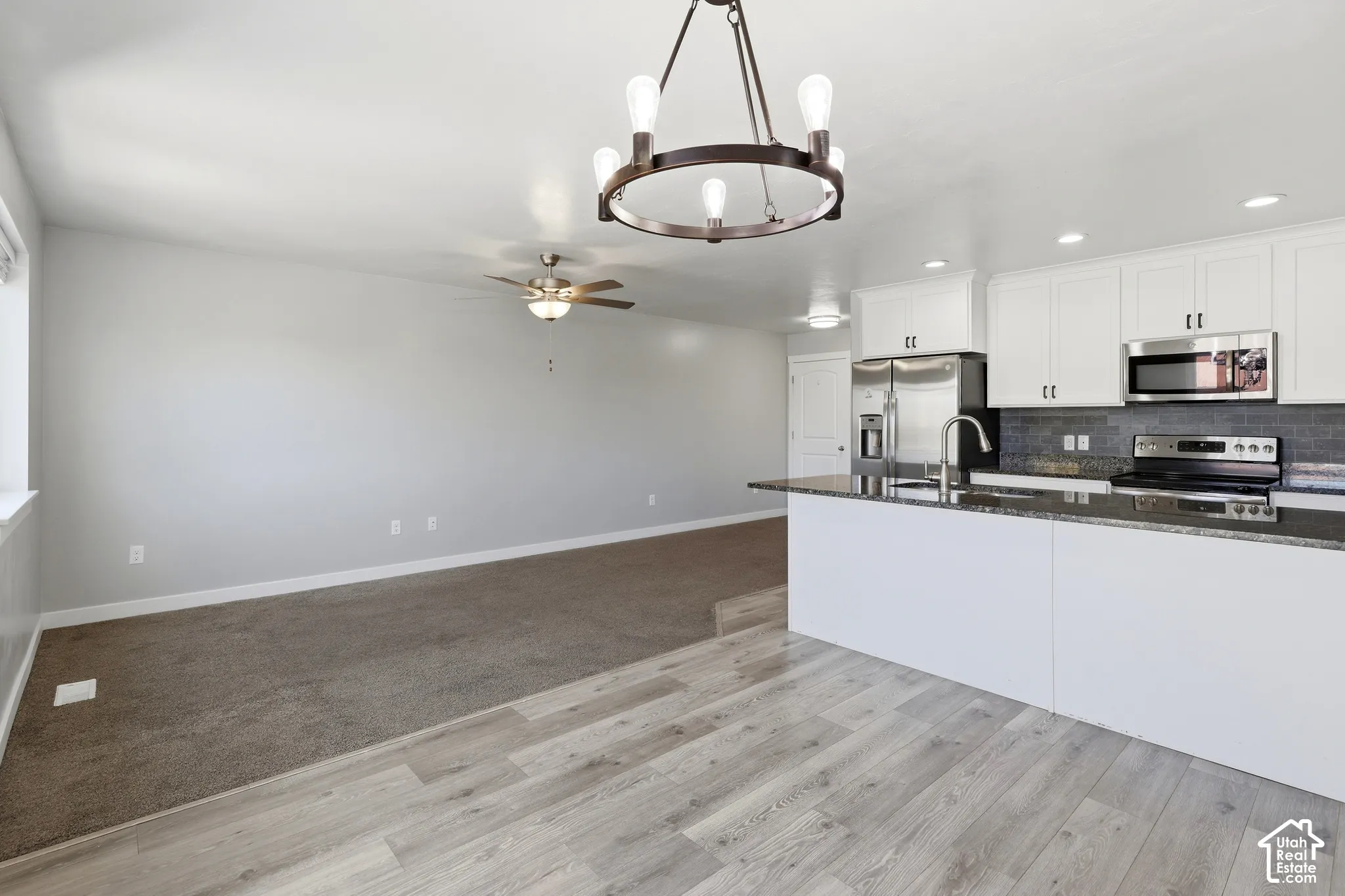 Kitchen featuring a dark stone countertop, white cabinetry, and stainless steel appliances