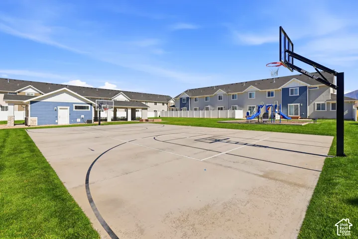 Outdoor sport court, playground area, and covered patio with exterior lighting