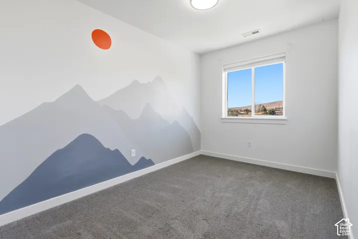 Wall with mountain motif mural and accent sun detail, featuring a window with a white frame, and gray carpet