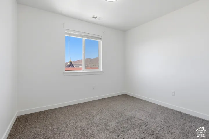Neutral wall finishes, window with mountain scenery, recessed ceiling lighting, and soft carpet flooring