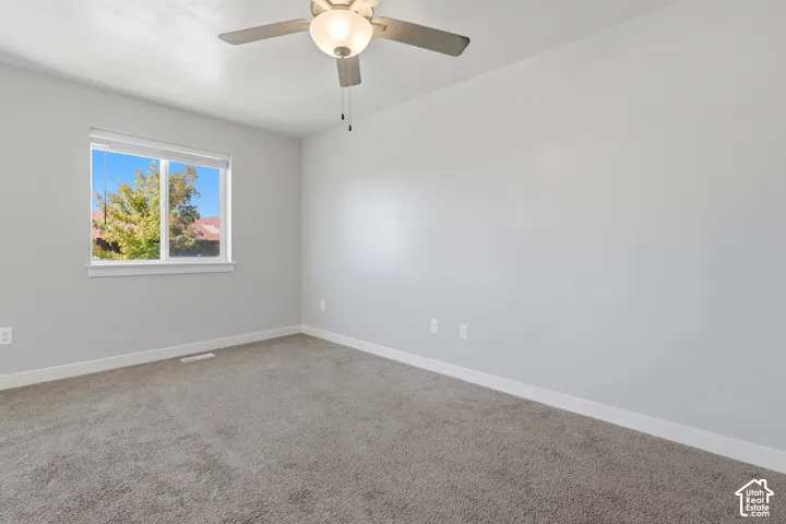 Recessed window with white trim, gray wall paint, white ceiling, ceiling fan with integrated lighting, and gray carpet