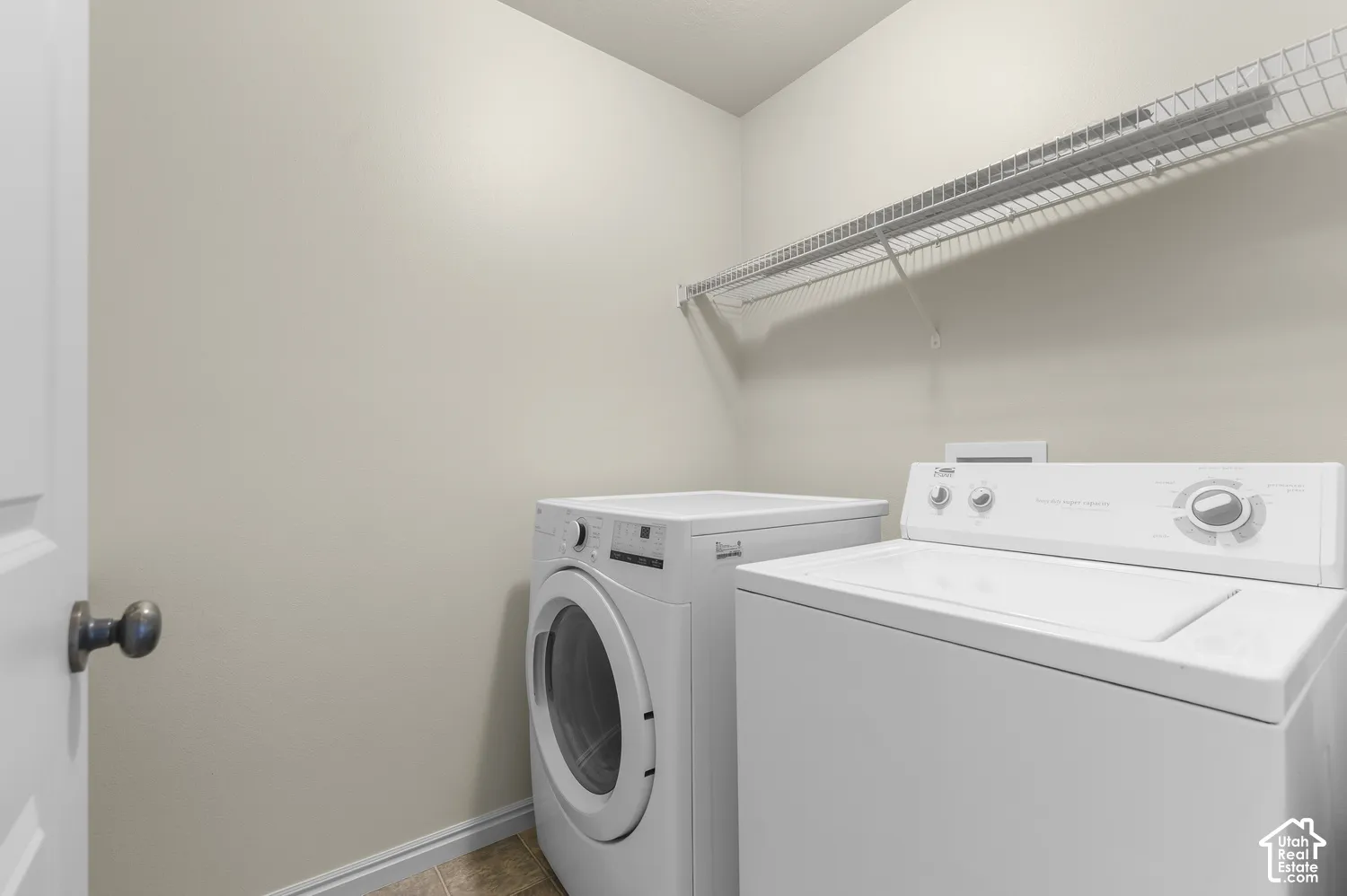 Upstairs-Dedicated laundry area featuring a wire storage shelf and light-toned wall paint