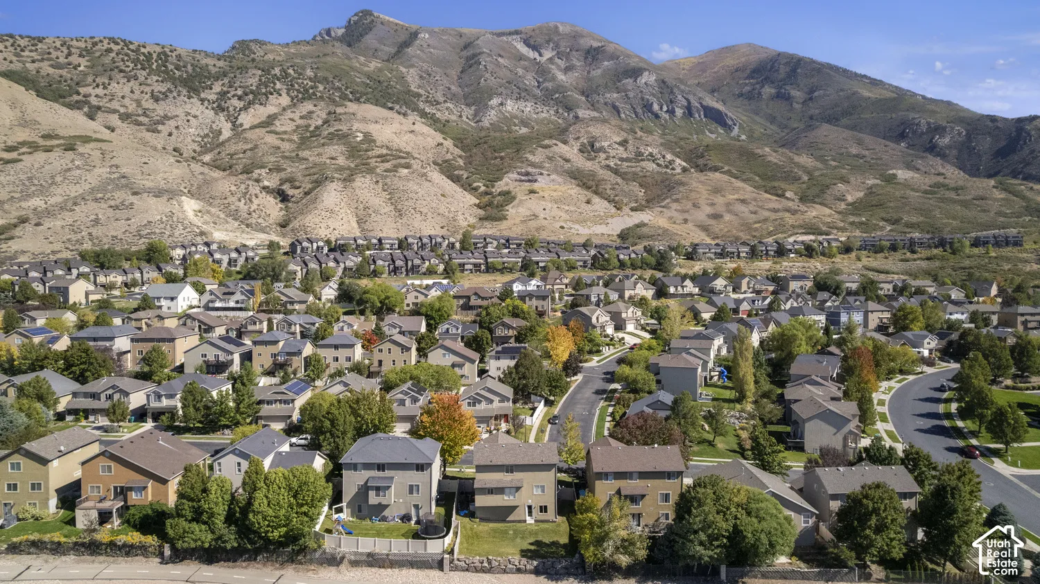 Established residential community nestled against dramatic mountain backdrop, featuring tree-lined streets, diverse architectural styles, and mature landscaping throughout the neighborhood