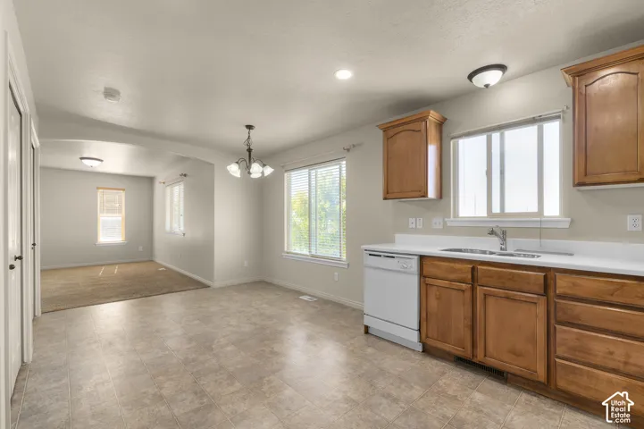 Kitchen area with wood cabinetry, white countertops, and a double-basin sink