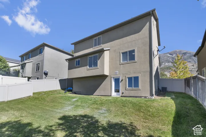 Rear Exterior-Expansive lawn area with a white vinyl fence