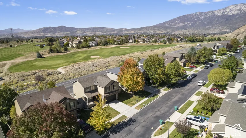 Community with paved streets and sidewalks, bordered by a golf course and mountain backdrop