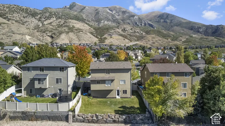 Manicured backyard with a white privacy fence and a mountain backdrop