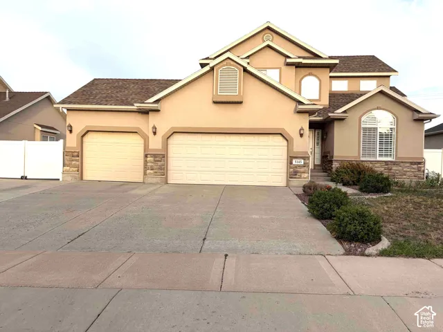 Stucco exterior with stone accents and two attached garages
