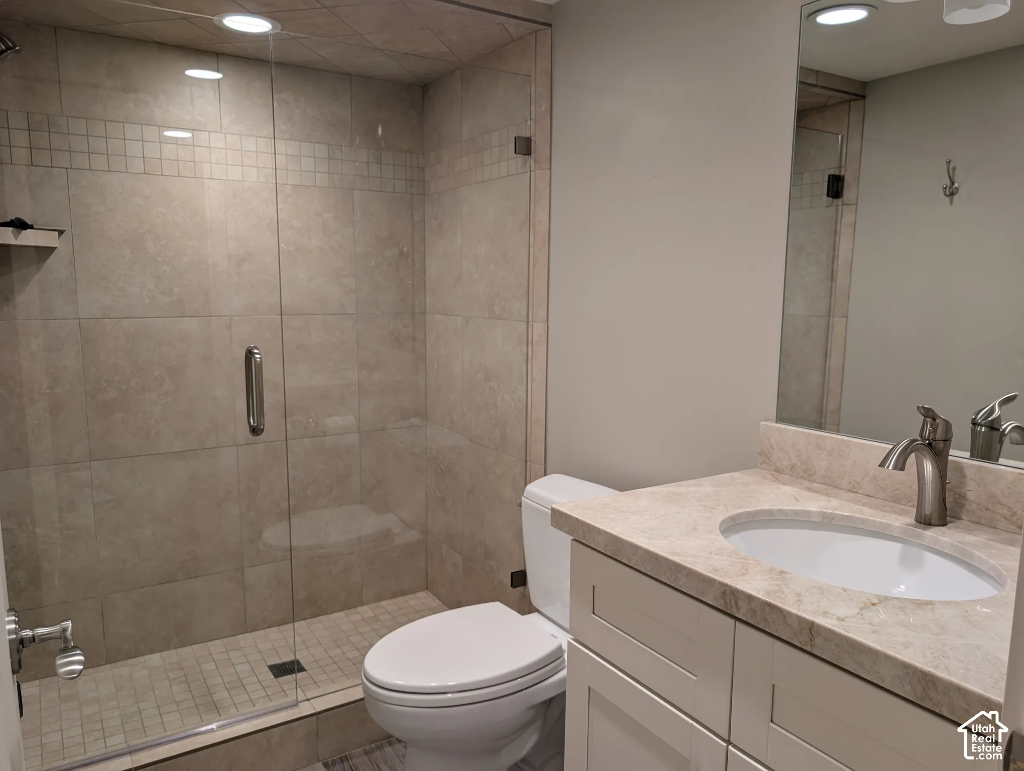Glass-enclosed shower with tiled walls and floor