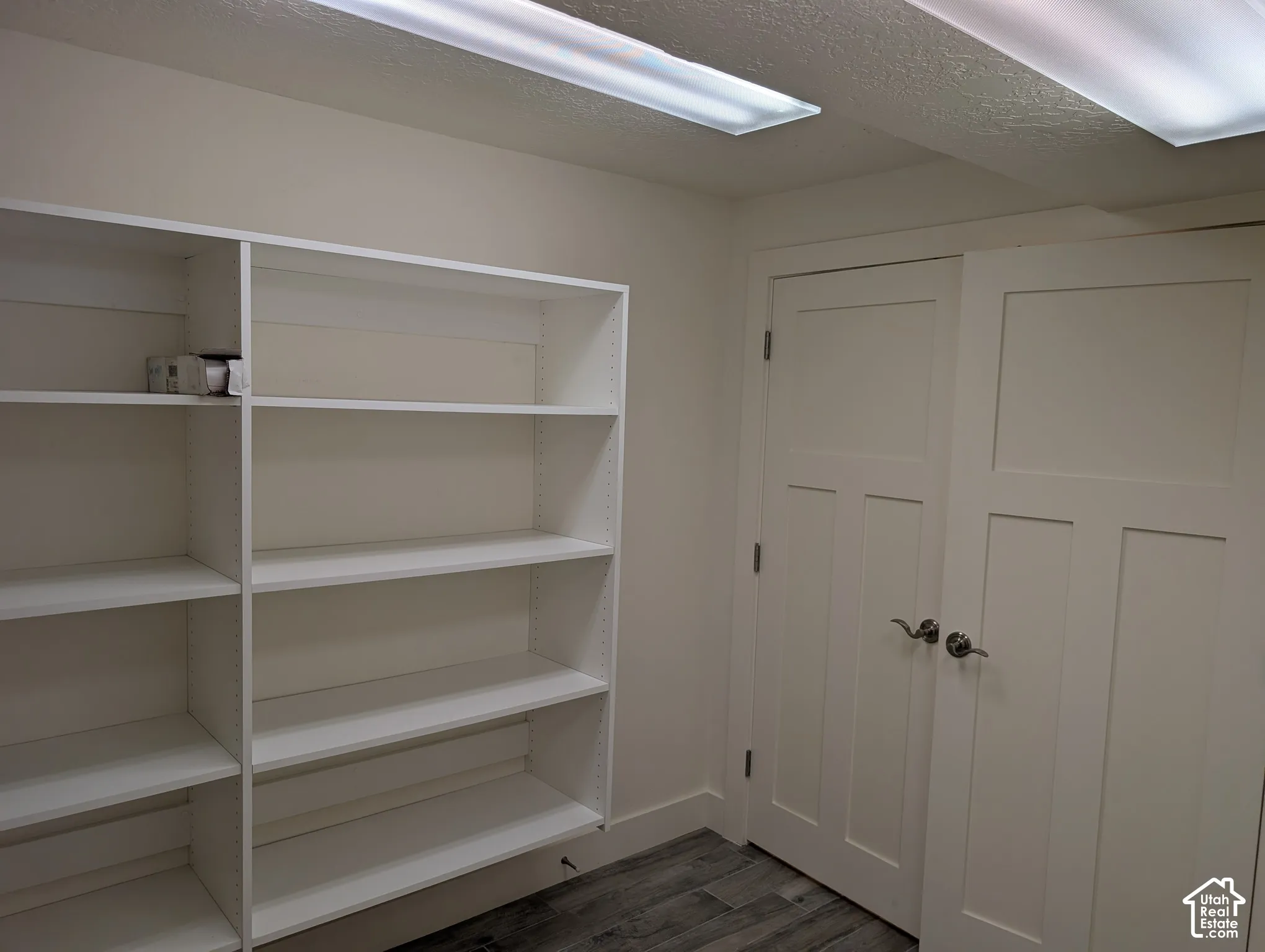 Built-in shelving, two panel interior doors with brushed nickel hardware, and wood-finish flooring