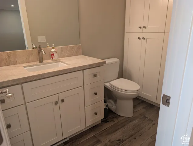 White shaker-style vanity with an undermount sink and a stone countertop