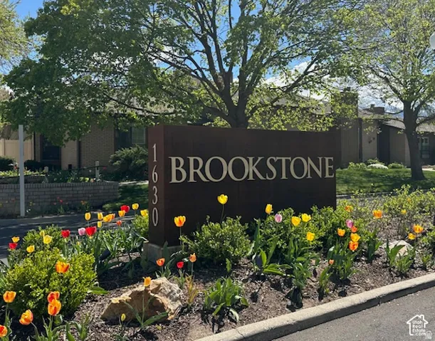 Community signage with integrated address numbers and lush landscaping