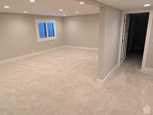 Recessed lighting, light-toned carpeting, neutral wall paint, white trim, and a window with white shutters