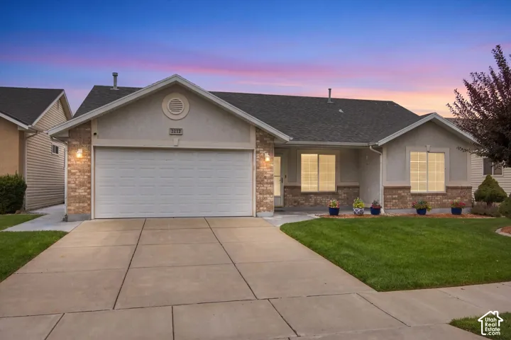 Single-story residence featuring a two-car garage, brick and stucco exterior, and a concrete driveway