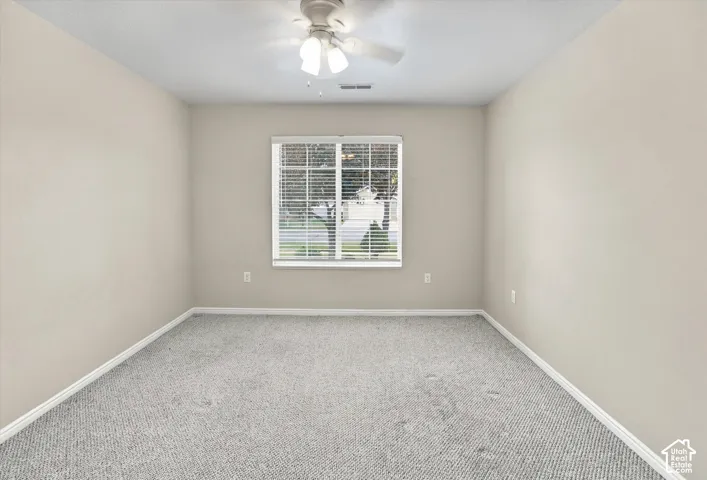 Recessed window with horizontal blinds, overhead ceiling fan, and carpeted flooring