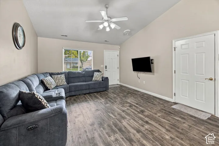 Vaulted ceiling, wood-finish flooring, ceiling fan, natural light window, and panel doors