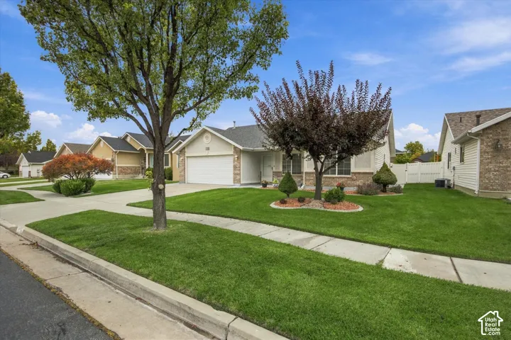 Front exterior with an attached garage, landscaped yard, and concrete driveway