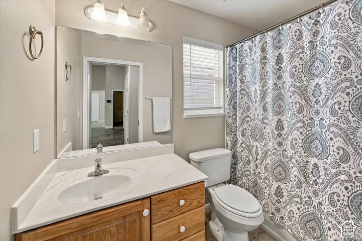 White vanity with integrated sink, chrome faucet, and wood-finish cabinetry