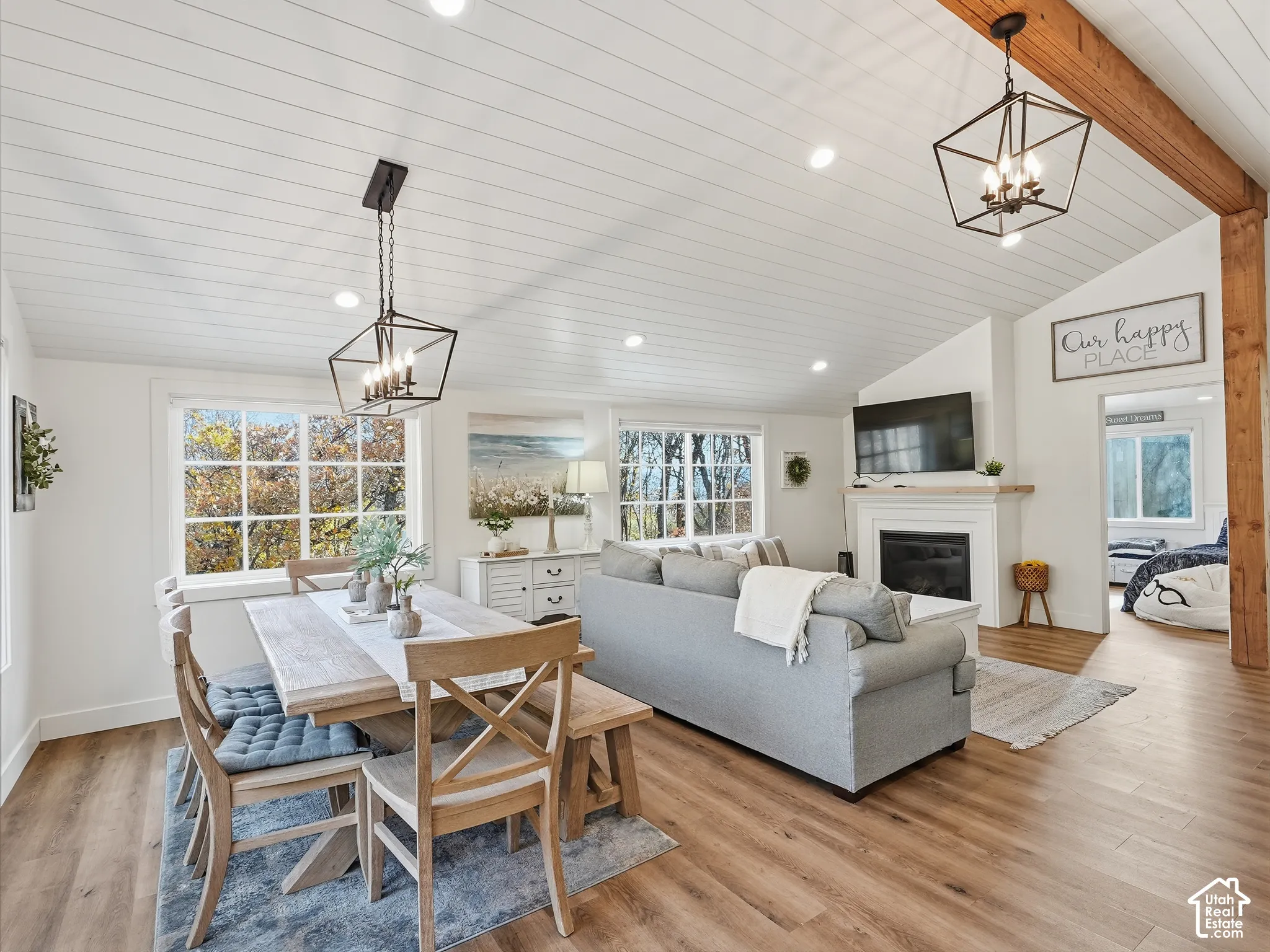 Vaulted ceilings with shiplap paneling and exposed wood beams, wood-finish flooring, recessed lighting, and a fireplace with a mantel