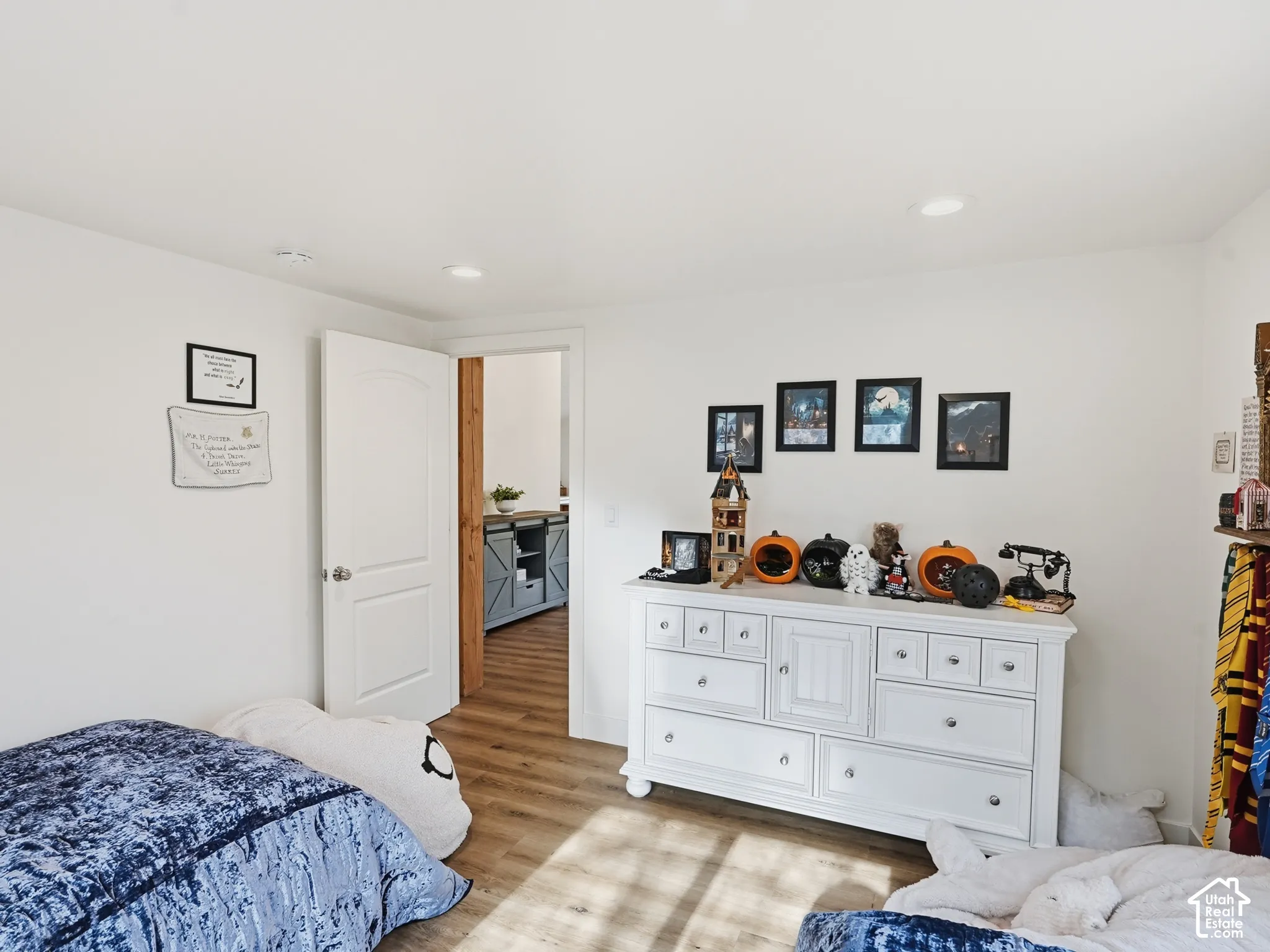 Neutral-toned room featuring wood-finish flooring, recessed lighting, and a white interior door