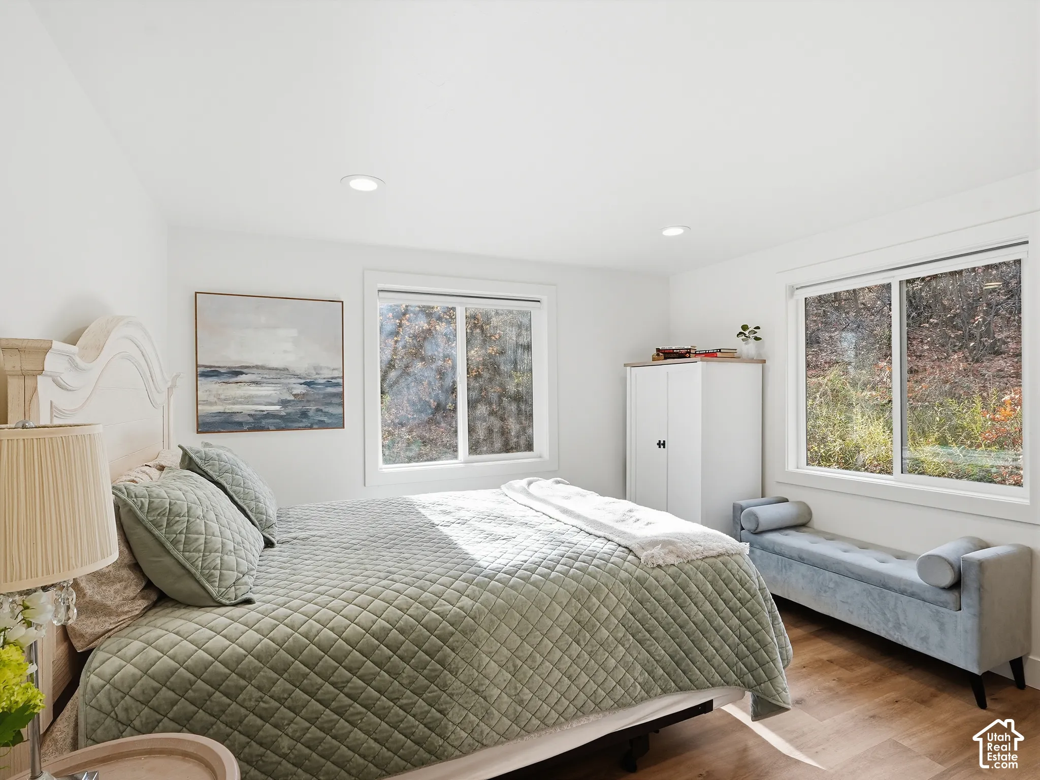 Room featuring wood-finish flooring, recessed lighting, and two expansive windows