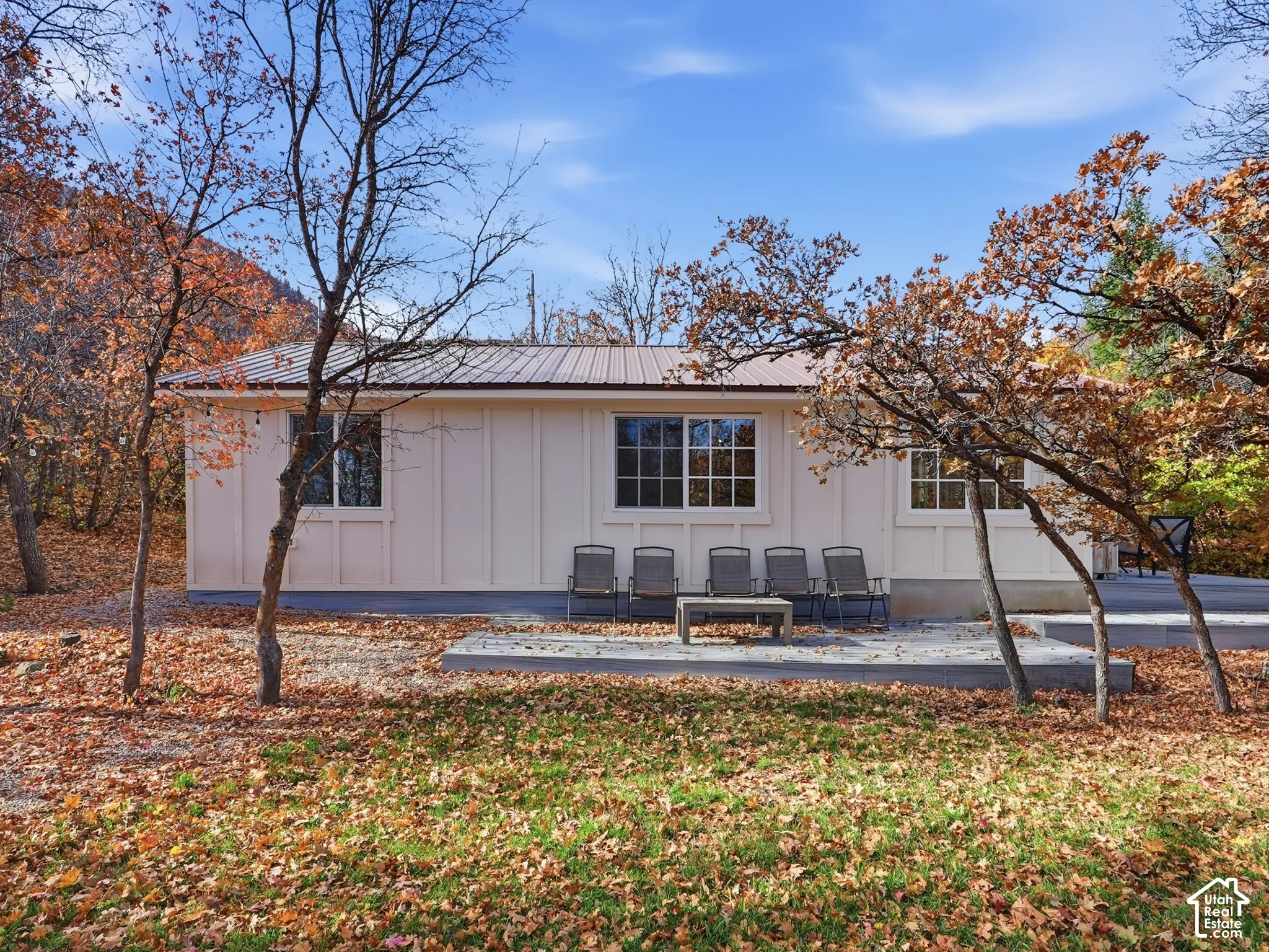 Board-and-batten siding, metal roof, multi-pane windows, and a concrete patio