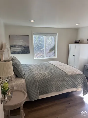 Recessed ceiling lighting, wood-finish flooring, white trim, and a white window frame