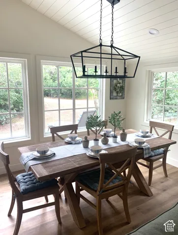 Vaulted ceiling with shiplap finish, wood-finish flooring, and multiple large windows