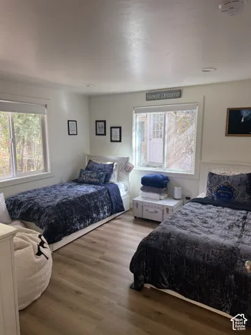 Wood-finish flooring with white trim, recessed lighting, and dual windows
