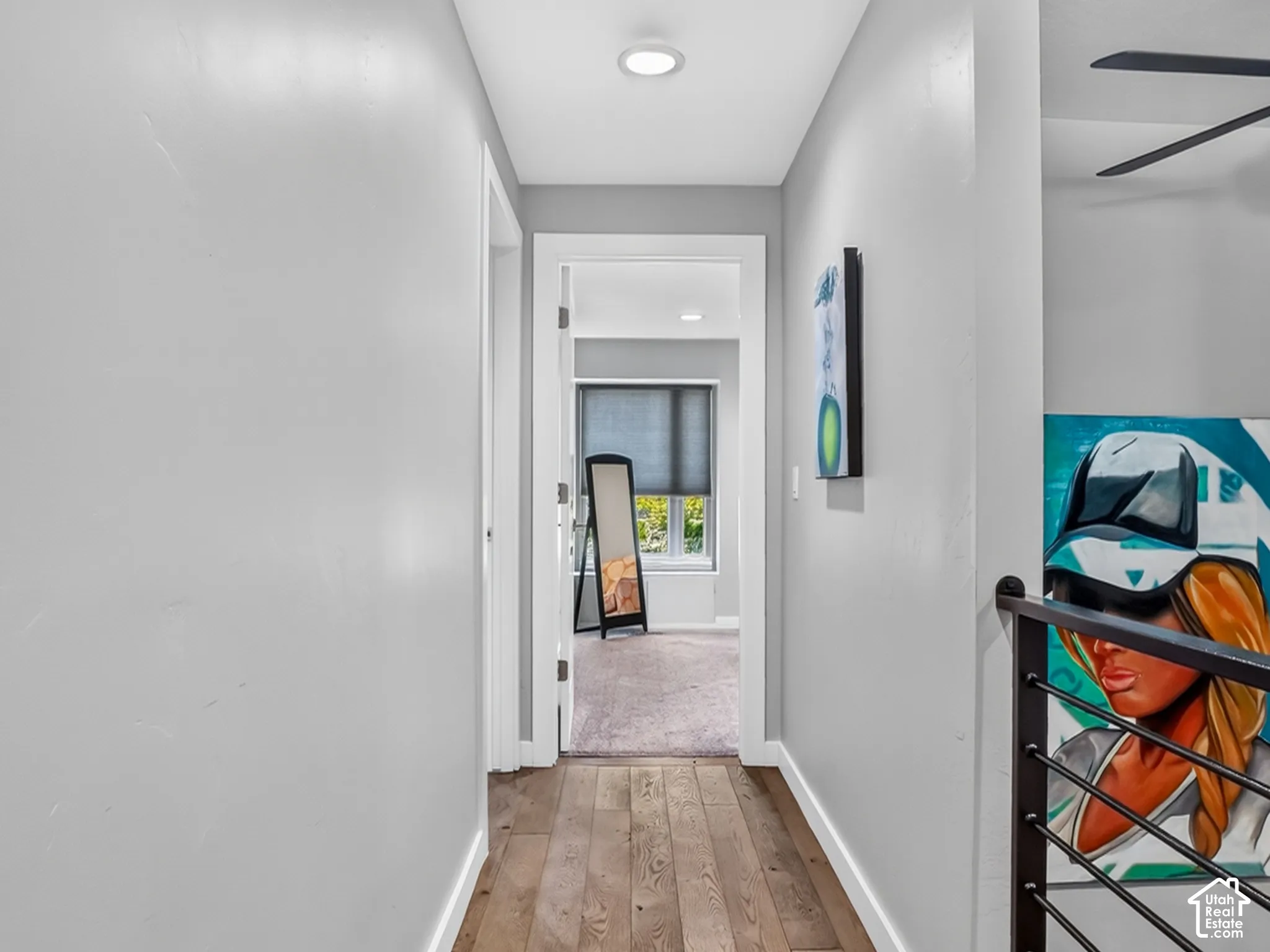 Hardwood flooring, recessed lighting, and a black metal railing