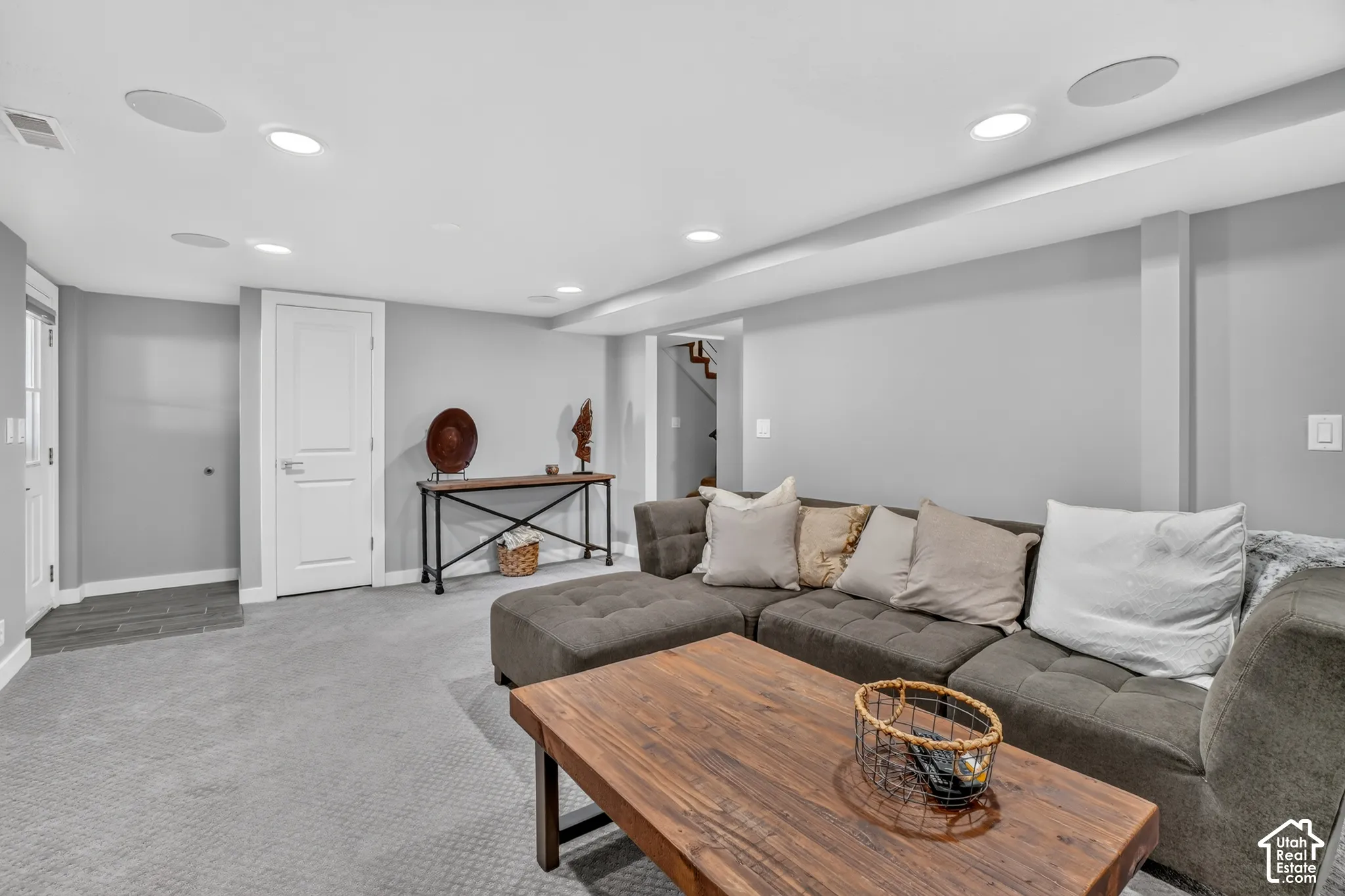 Recessed lighting, light gray wall finishes, carpeted flooring, and a white paneled door